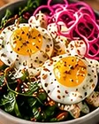Nourishment Breakfast Bowl: fried eggs over sweet potatoes, greens and pickled onions
